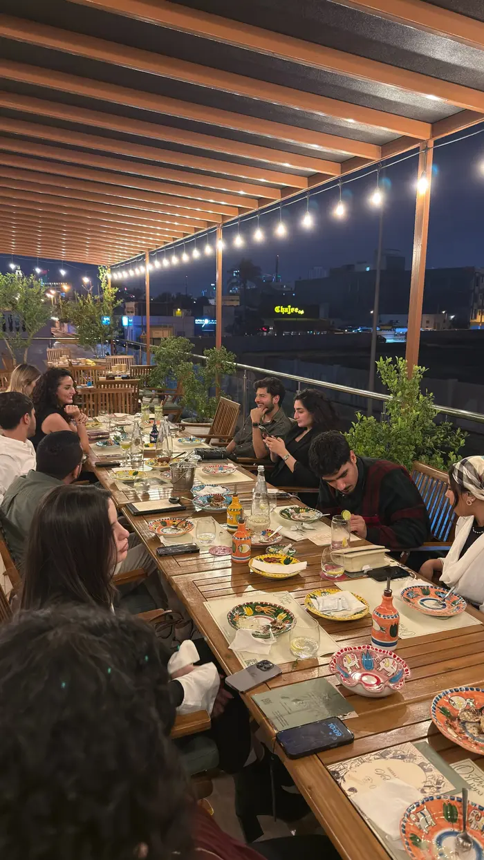 Members gathered around the long table at Osteria